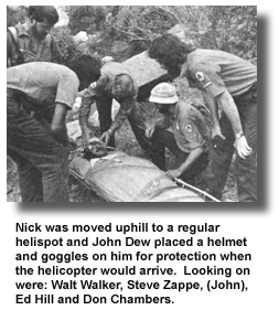 Nick was moved uphill to a regular helispot and John Dew placed a helmet and goggles on him for protection when the helicopter would arrive. Looking on were: Walt Walker, Steve Zappe, (John), Ed Hill and Don Chambers.