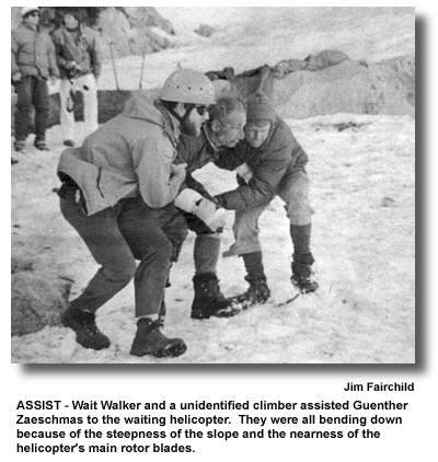 ASSIST - Walt Walker and a unidentified climber assisted Guenther Zaeschmas to the waiting helicopter. They were all bending down because of the steepness of the slope and the nearness of the helicopter's main rotor blades. (photo by Jim Fairchild)
