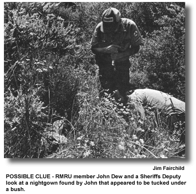 POSSIBLE CLUE - RMRU member John Dew and a Sheriffs Deputy look at a nightgown found by John that appeared to be tucked under a bush. (photo by Jim Fairchild)