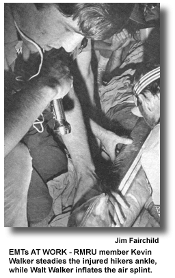 EMTs AT WORK - RMRU member Kevin Walker steadies the injured hikers ankle, while Walt Walker inflates the air splint. (photo by Jim Fairchild)