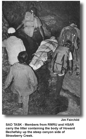 SAD TASK - Members from RMRU and HSAR carry the litter containing the body of Howard Bechefsky up the steep canyon side of Strawberry Creek. (photo by Jim Fairchild)