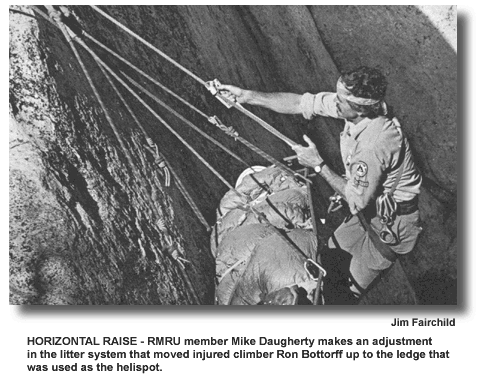 HORIZONTAL RAISE - RMRU member Mike Daugherty makes an adjustment in the litter system that moved injured climber Ron Bottorff up to the ledge that was used as the helispot. (photo by Jim Fairchild)