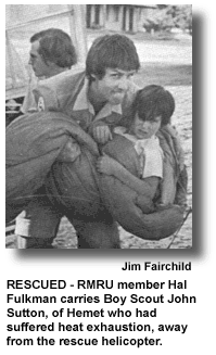 RESCUED - RMRU member Hal Fulkman carries Boy Scout John Sutton, of Hemet who had suffered heat exhaustion, away from the rescue helicopter. (photo by Jim Fairchild)