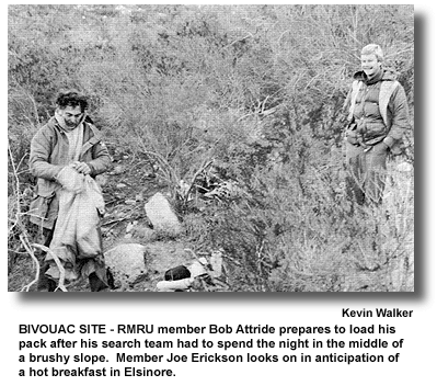 BIVOUAC SITE - RMRU member Bob Attride prepares to load his pack after his search team had to spend the night in the middle of a brushy slope. Member Joe Erickson looks on in anticipation of a hot breakfast in Elsinore. (photo by Kevin Walker)