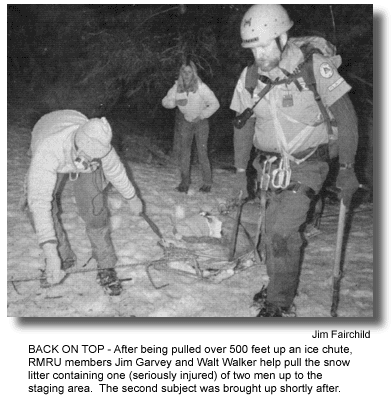 BACK ON TOP - After being pulled over 500 feet up an ice chute, RMRU members Jim Garvey and Walt Walker help pull the snow litter containing one (seriously injured) of two men up to the staging area. The second subject was brought up shortly after. (photo by Jim Fairchild)