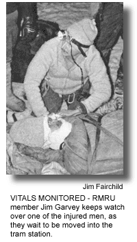 VITALS MONITORED - RMRU member Jim Garvey keeps watch over one of the injured men, as they wait to be moved into the tram station. (photo by Jim Fairchild)