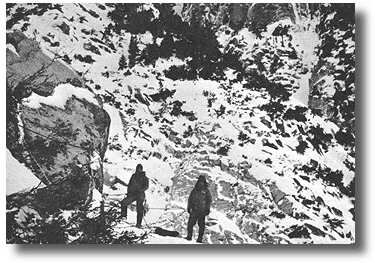 RMRU members Kevin and Walt Walker stand on the narrow ledge that was used for a helispot during the rescue of Kenneth Kenaga. Walt standing furthest to the right is near where the right skid of the helicopter touched down. Kevin on the left is standing approximately where the end of the rotor blades were turning by the rock face.