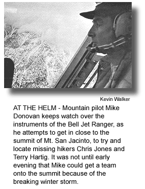 AT THE HELM - Mountain pilot Mike Donovan keeps watch over the instruments of the Bell Jet Ranger, as he attempts to get in close to the summit of Mt. San Jacinto, to try and locate missing hikers Chris Jones and Terry Hartig. It was not until early evening that Mike could get a team onto the summit because of the breaking winter storm. (photo by Kevin Walker)