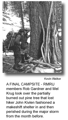 A FINAL CAMPSITE - RMRU members Rob Gardner and Mel Krug look over the partially burned out pine tree that lost hiker John Kivlen fashioned a makeshift shelter in and then perished during the major storm from the month before. (photo by Kevin Walker)