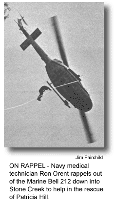 ON RAPPEL - Navy medical technician Ron Orent rappels out of the Marine Bell 212 down into Stone Creek to help in the rescue of Patricia Hill. (photo by Jim Fairchild)