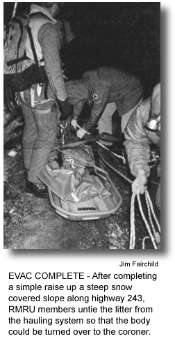 EVAC COMPLETE - After completing a simple raise up a steep snow covered slope along highway 243, RMRU members untie the litter from the hauling system so that the body could be turned over to the coroner. (photo by Jim Fairchild)