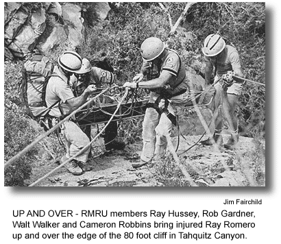 UP AND OVER - RMRU members Ray Hussey, Rob Gardner, Walt Walker and Cameron Robbins bring injured Ray Romero up and over the edge of the 80 foot cliff in Tahquitz Canyon. (photo by Jim Fairchild)