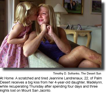 At Home: A Scratched and Tired Jeannine Landrenaux, 22, of Palm Desert receives a big kiss from her 4-year-old daughter, Madelynn, while recuperating Thursday after spending four days and three nights lost on Mount San Jacinto. (photo by Timothy D. Sofranko, The Desert Sun)