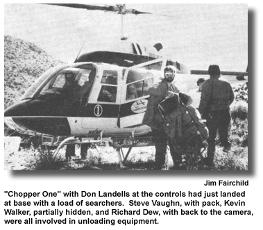 "Chopper One" with Don Landells at the controls had just landed at base with a load of searchers. Steve Vaughn, with pack, Kevin Walker, partially hidden, and Richard Dew, with back to the camera, were all involved in unloading equipment. (photo by Jim Fairchild)