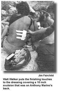Walt Walker puts the finishing touches to the dressing covering a 10 inch avulsion that was on Anthony Marino's back. (photo by Jim Fairchild)
