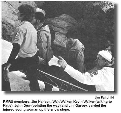 RMRU members, Jim Hanson, Walt Walker, Kevin Walker (talking to Katie), John Dew (pointing the way) and Jim Garvey, carried the injured young woman up the snow slope. (photo by Jim Fairchild)