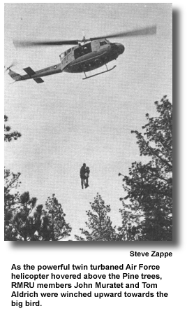 As the powerful twin turbaned Air Force helicopter hovered above the Pine trees, RMRU members John Muratet and Tom Aldrich were winched upward towards the big bird. (photo by Steve Zappe)