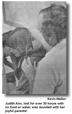 RESCUED GIRL - After having been found by a RMRU tracking team, flown to the base of operations by a Marine helicopter, Judith Ann was assisted by a Marine crewman and RMRU member Kevin Walker. (photo by Larry Roland)