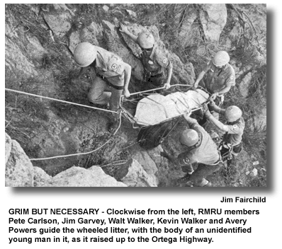 GRIM BUT NECESSARY - Clockwise from the left, RMRU members Pete Carlson, Jim Garvey, Walt Walker, Kevin Walker and Avery Powers guide the wheeled litter, with the body of an unidentified young man in it, as it raised up to the Ortega Highway. (photo by Jim Fairchild)