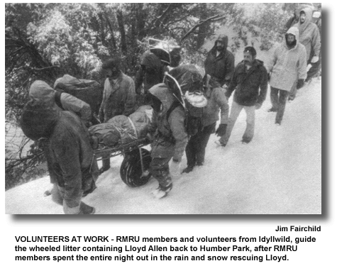 VOLUNTEERS AT WORK – RMRU members and volunteers from Idyllwild, guide the wheeled litter containing Lloyd Allen back to Humber Park, after RMRU members spent the entire night out in the rain and snow rescuing Lloyd. (photo by Jim Fairchild)