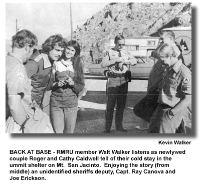 BACK AT BASE - RMRU member Walt Walker listens as newlywed couple Roger and Cathy Caldwell tell of their cold stay in the summit shelter on Mt. San Jacinto. Enjoying the story (from middle) an unidentified sheriffs deputy, Capt. Ray Canova and Joe Erickson. (photo by Kevin Walker)