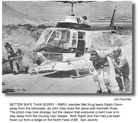 BETTER SAFE THAN SORRY - RMRU member Mel Krug leads Ralph Glenn away from the helicopter, as John Dew does the same with Kenneth Rose. The photo may look strange, but the reason that everyone is bent over is to stay away from the moving rotor blades. Both Ralph and Ken had just been flown out from a ledge on the North Face of Mt. San Jacinto. (photo by Jim Fairchild)