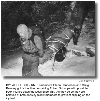 ICY WHEEL OUT – RMRU members Glenn Henderson and Craig Beasley guide the litter containing Robert Schuppe with possible back injuries down the Devil Slide trail. As they do so they are belayed at both ends by fellow members to prevent slipping on the icy trail. (photo by Jim Fairchild)